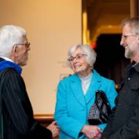 Faculty conversing with guests